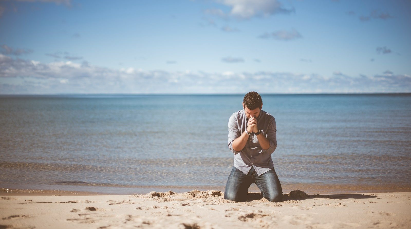 man kneeling down near shore